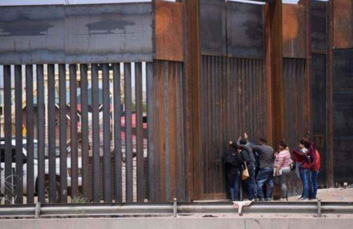 Migrantes centroamericanos se asoman en por el muro fronterizo, para entregarse a las autoridades migratoria estadounidenses, en el tramo de Puente Nuevo, en Ciudad Juárez (México). EFE/ Rey R. Jauregui/Archivo