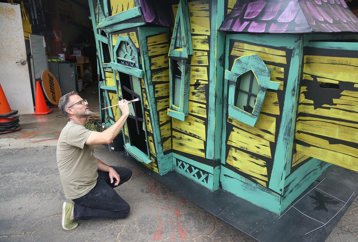 Kevin Kindney puts the finishing touches on a revamped haunted house float at an Anaheim warehouse.