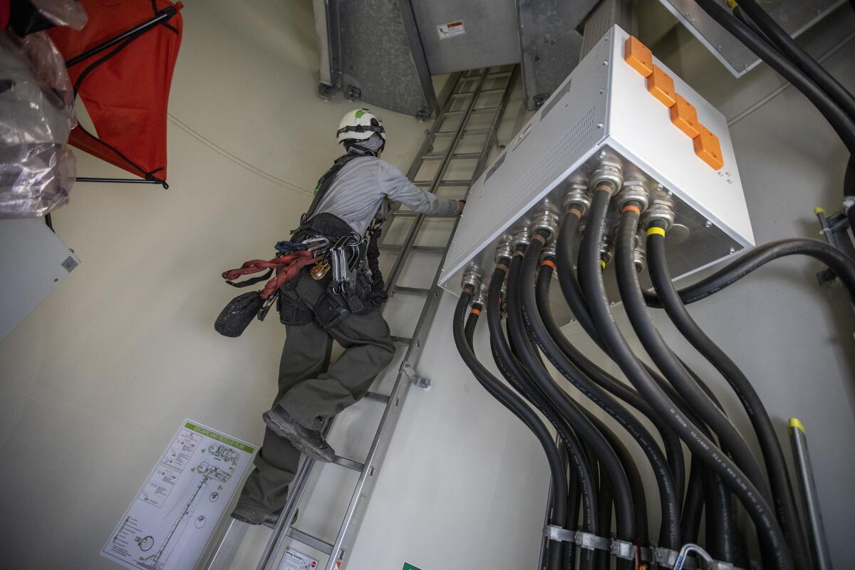 Rope Partner's Matthew Kelly climbs a ladder inside a 262-foot-high tower at the Shiloh II wind farm.