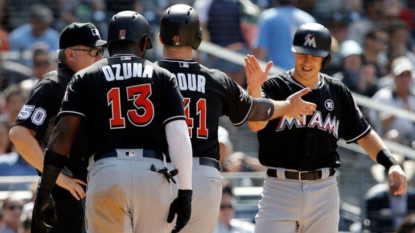 The Miami Marlins' Marcell Ozuna, left, and J.T. Realmuto, right, congratulate Justin Bour, center, for his three-run home run against the San Diego Padres at Petco Park on April 23.
