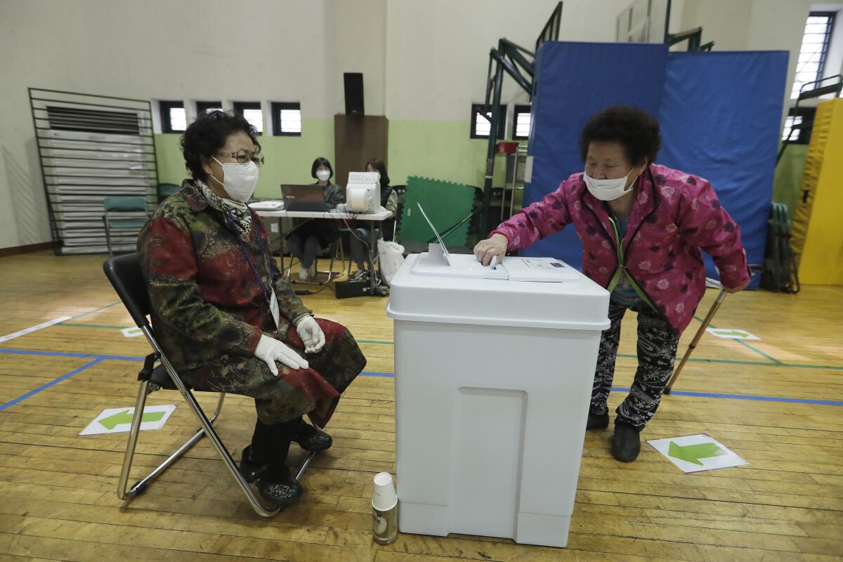 A voter drops her ballot into a box Friday during early voting. Wednesday is election day.