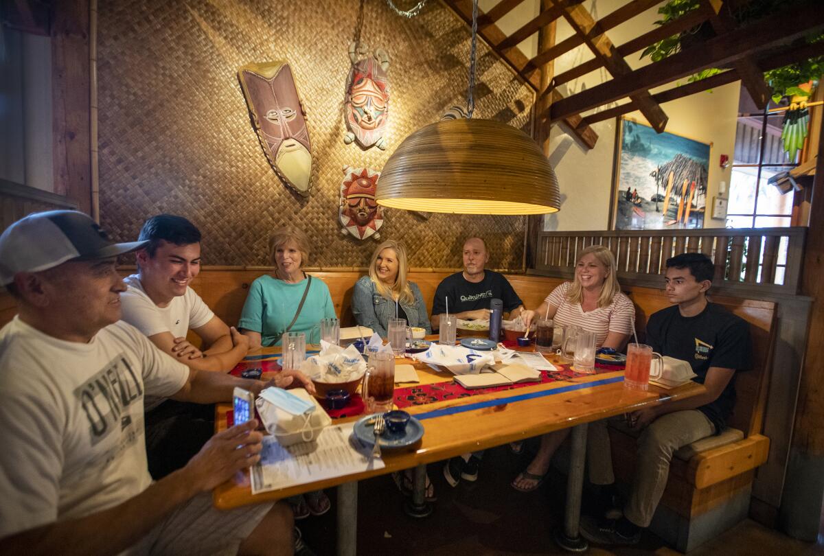 A family celebrates birthdays with an indoor dinner at Islands Restaurant in Huntington Beach on Tuesday.