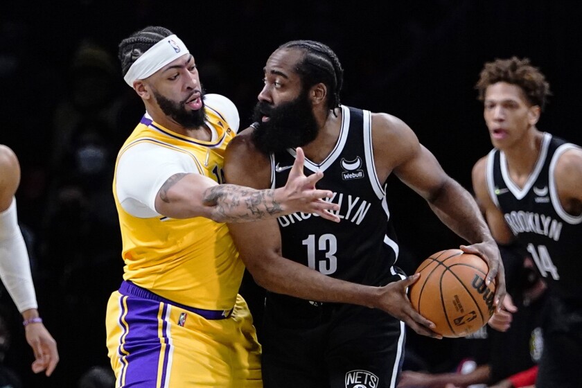 Lakers forward Anthony Davis, left, defends against Brooklyn Nets guard James Harden during the Lakers' win Tuesday.