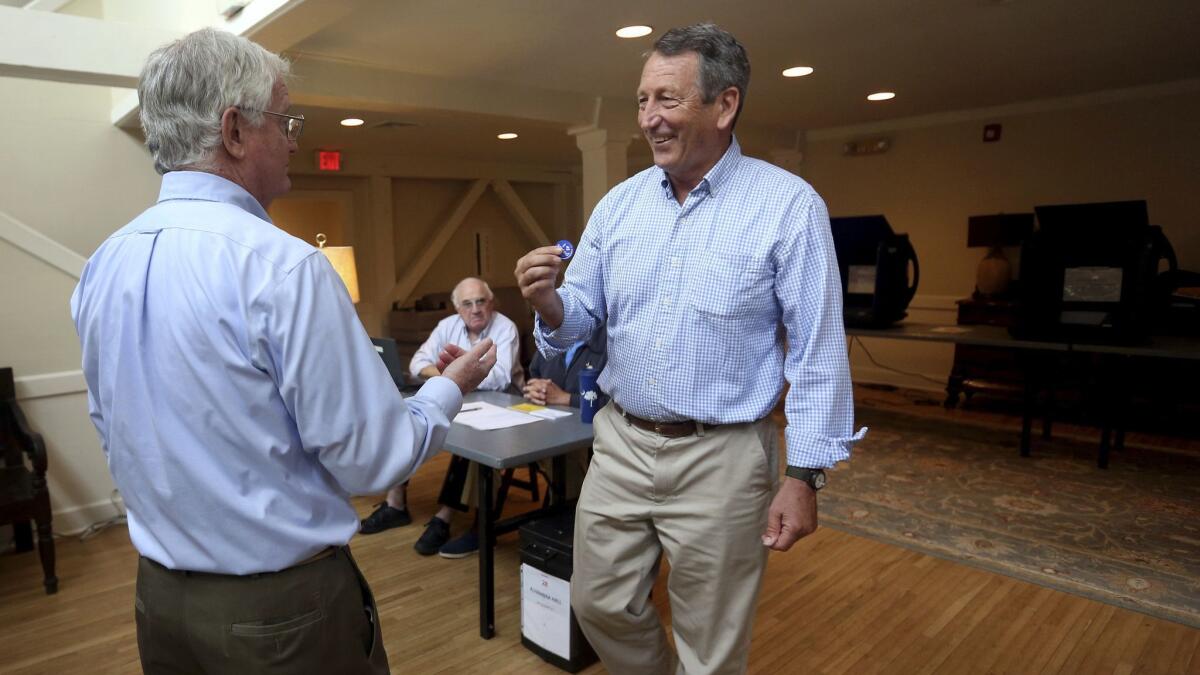 Poll volunteer Tom Spain, left, talks with former Gov, Mark Sanford in Mt. Pleasant, S.C.