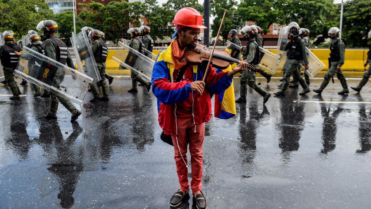 Opposition activist Wuilly Arteaga plays his violin during a protest against President Nicolas Maduro last month in Caracas.