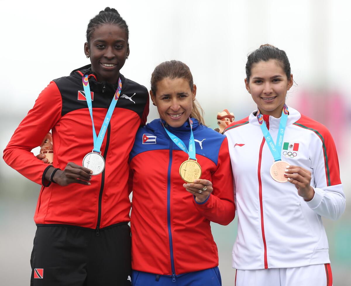 From L to R Trinidad and Tobago's Teniel Campbell, Cuba's Arlenis Sierra and Mexico's Ariadna Gutierrez stand at the podium after winning the silver, gold and bronze medals respectively in the Cycling Road Race Women's Finals at the Lima 2019 Pan-American Games in Lima on August 10, 2019. (Photo by LUKA GONZALES / AFP)LUKA GONZALES/AFP/Getty Images ** OUTS - ELSENT, FPG, CM - OUTS * NM, PH, VA if sourced by CT, LA or MoD **