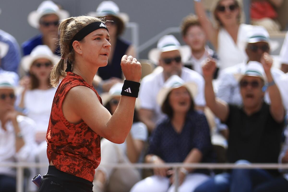 Karolina Muchova pumps her fist after scoring a point against Iga Swiatek in the French Open championship match.