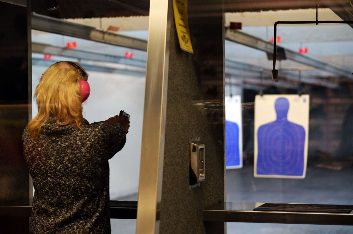A woman fires a gun at the Ultimate Defense Firing Range and Training Center in St. Peters, Mo. A Pew survey finds growing support for gun rights.