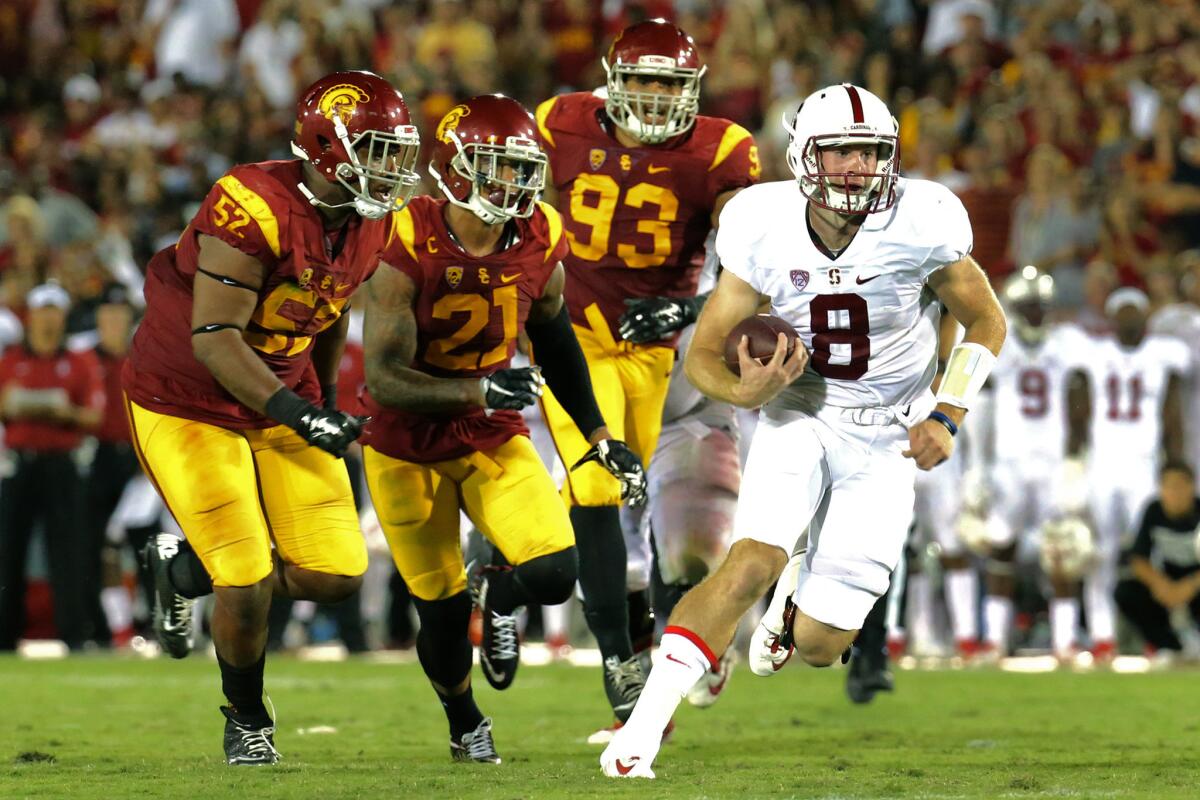 Stanford quarterback Kevin Hogan races past USC defenders for a first down run during the second half.