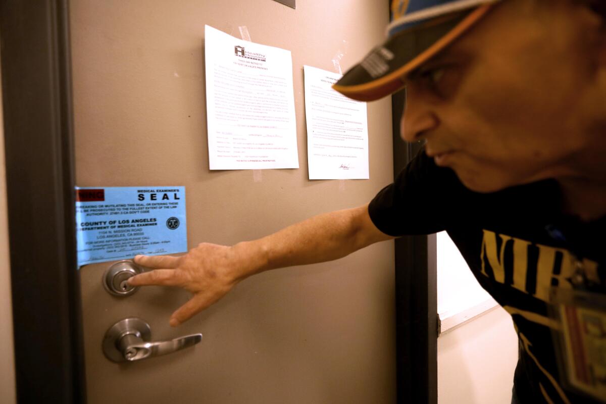 Tenant union leader Nash Stabolito reads a Medical Examiner's seal placed in June at the Baltimore Hotel in September.