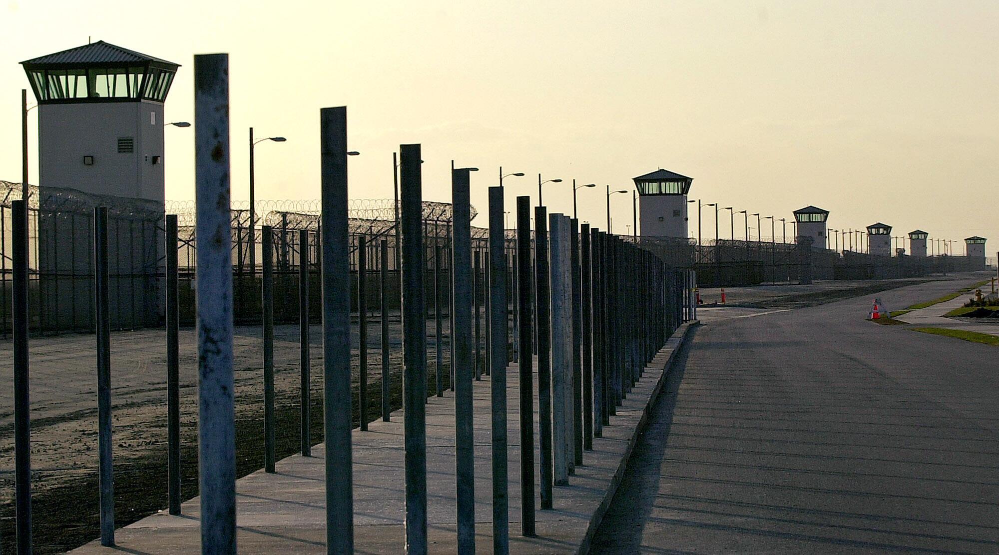 A fence runs along a long line of towers.