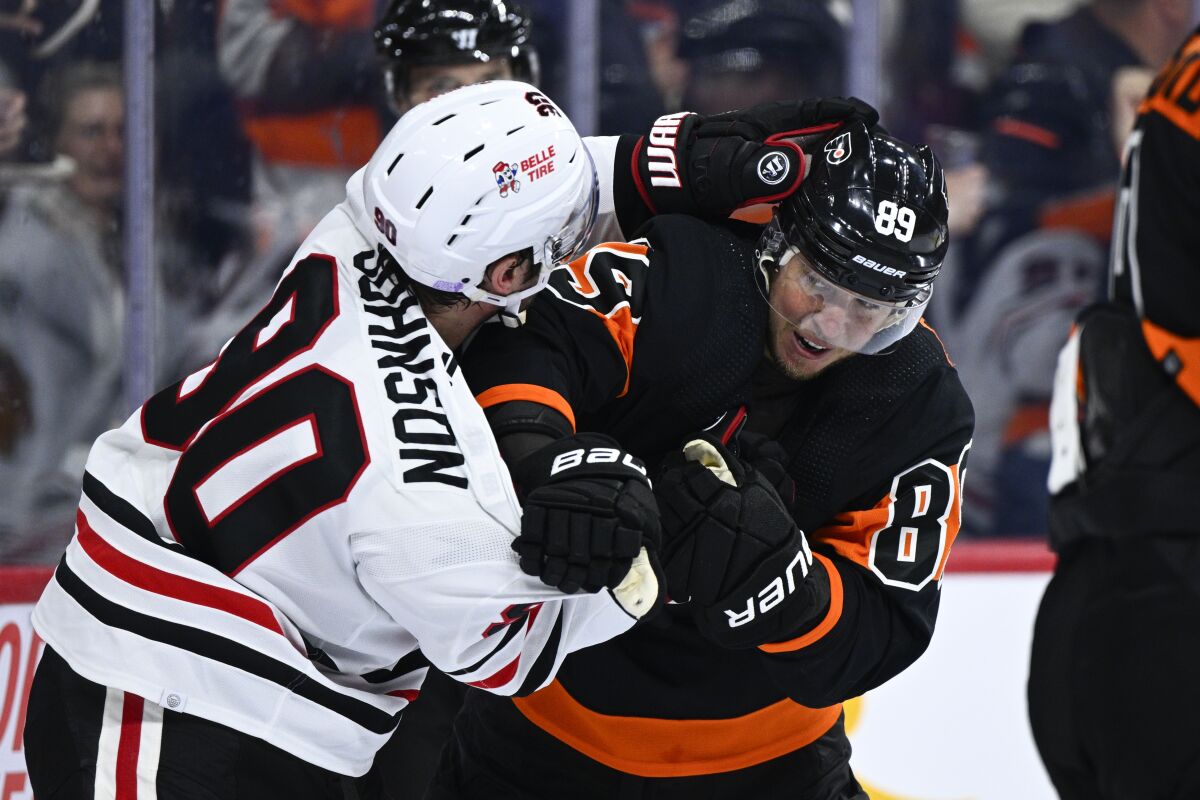 Philadelphia Flyers' Cam Atkinson, right, scuffles with Chicago Blackhawks' Tyler Johnson after Atkinson scored a goal during the second period of an NHL hockey game, Saturday, March 5, 2022, in Philadelphia. (AP Photo/Derik Hamilton)