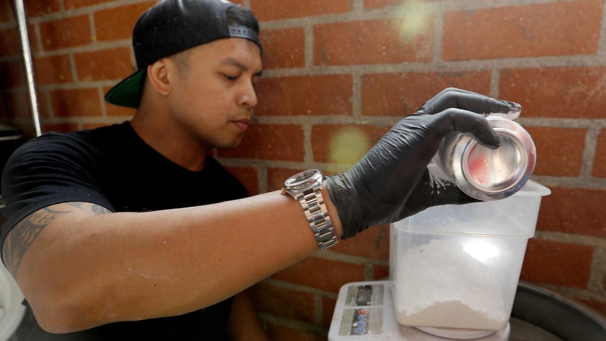 Brewer Charles Rapadas measures salts to harden water in the process of making beer at Three Chiefs Brewing in El Segundo.