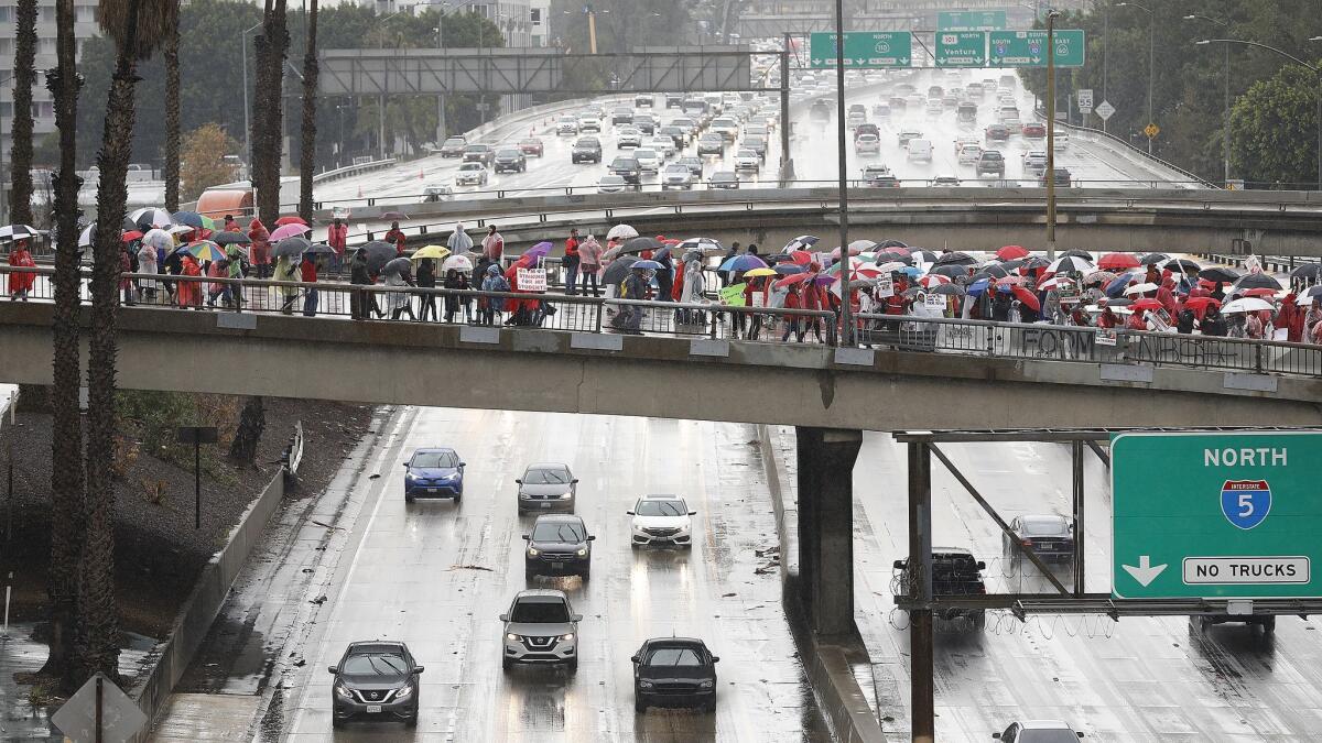 Teachers in a sea of umbrellas block 3rd and 4th streets over the 110 Freeway in downtown Los Angeles.