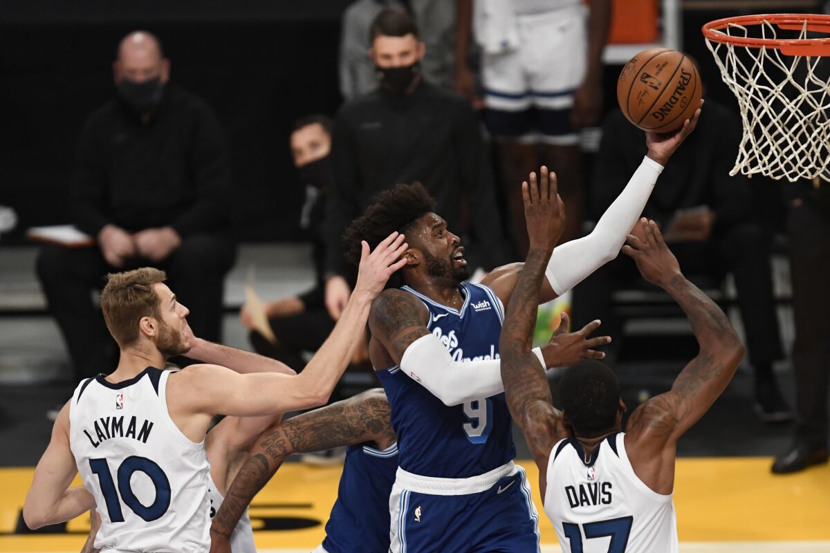 Lakers guard Wesley Matthews goes up for a basket over Minnesota Timberwolves forward Jake Layman and center Ed Davis.