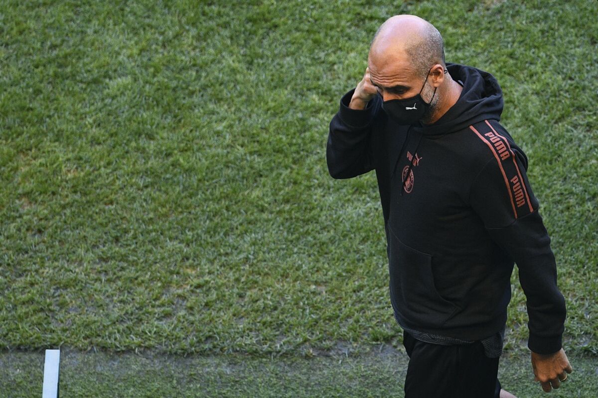 Manchester City's head coach Pep Guardiola walks on the pitch of the Jose Alvalade stadium in Lisbon, Friday Aug. 14, 2020. Manchester City will play Lyon in a Champions League quarterfinals soccer match on Saturday. (Franck Fife/Pool via AP)