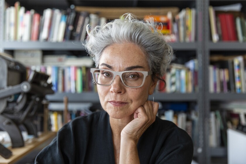 Artist and designer Rebeca Méndez in her book lined studio