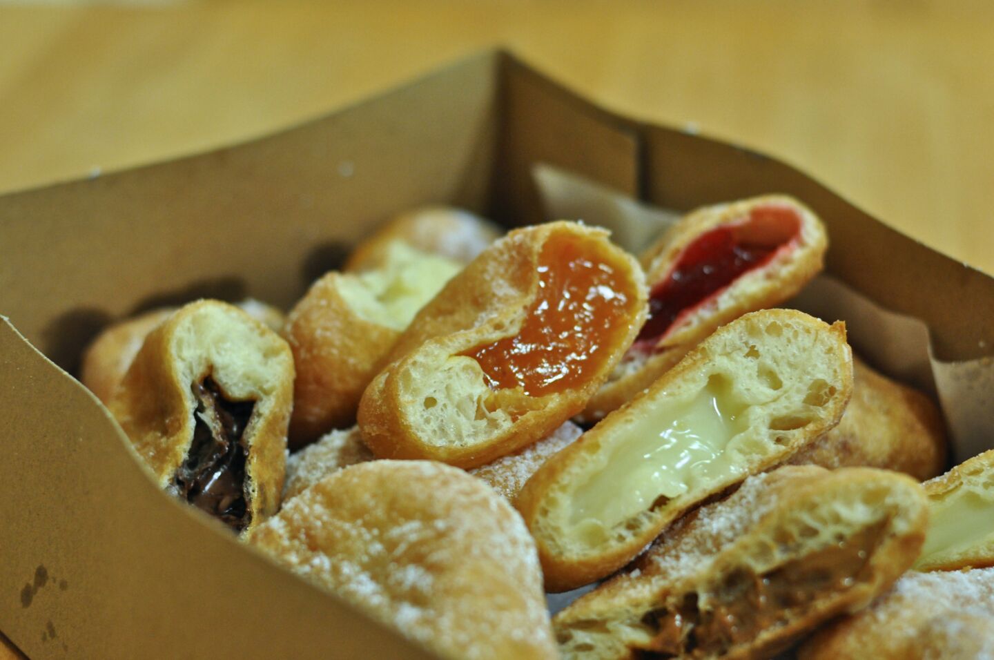 A box of a dozen ponchiks from Papillon International Bakery in Glendale, including apricot, raspberry, dulce de leche, custard and Nutella.