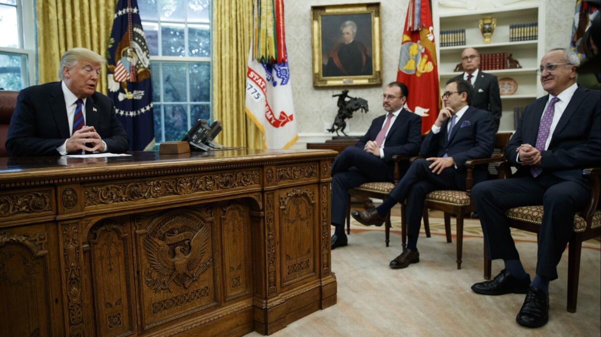 President Donald Trump talks on the phone with Mexican President Enrique Pena Nieto, in the Oval Office on Aug. 27.