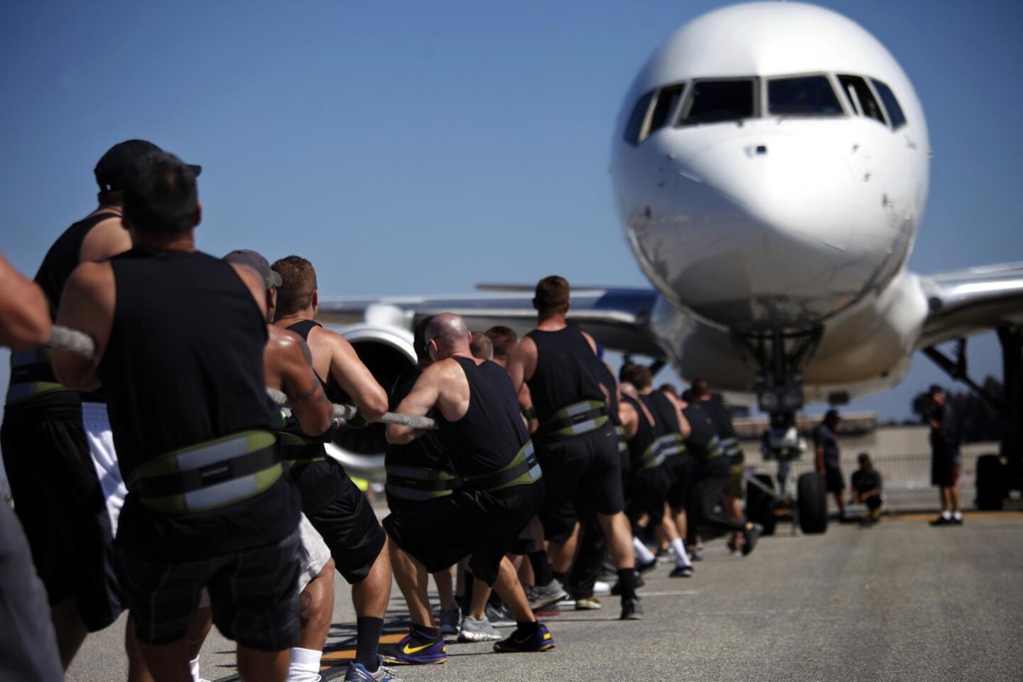 The Men's Central Jail team pulls a 164,000-pound Boeing 757 airplane as part of the ninth Annual Special Olympics Southern California's Plane Pull at the Long Beach Airport.