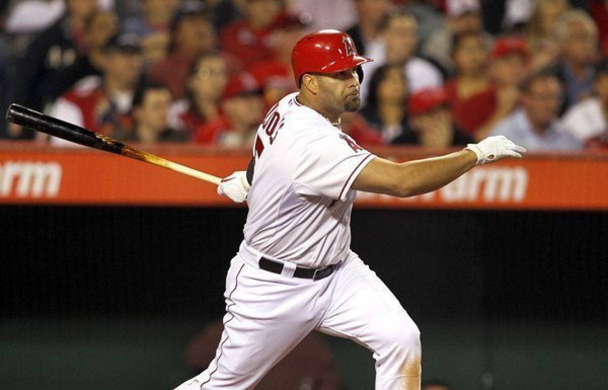 Angels first baseman Albert Pujols follows through on a single against Oakland early this month in Anaheim.