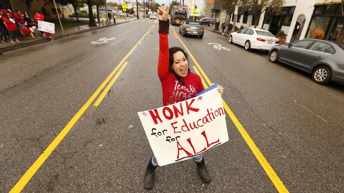 Westminster Elementary School kindergarten teacher Beth Clark stands in then middle of Abbot Kinney Boulevard in Venice imploring passing drivers to honk as teachers and supporters picket outside the school.