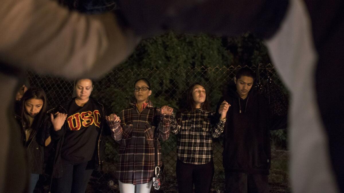 Family and friends join hands in prayer on Dec. 26, the fifth anniversary of Bree'Anna Guzman's disappearance. (Brian van der Brug / Los Angeles Times)