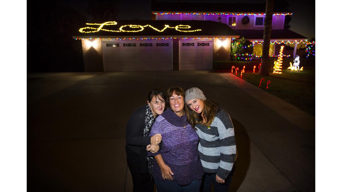 Trenna Miens, center, outside her home with daughters Tawyna, left, and Tina. Their husband and father Damian Meins was killed in the 2015 terrorist attack in San Bernardino.