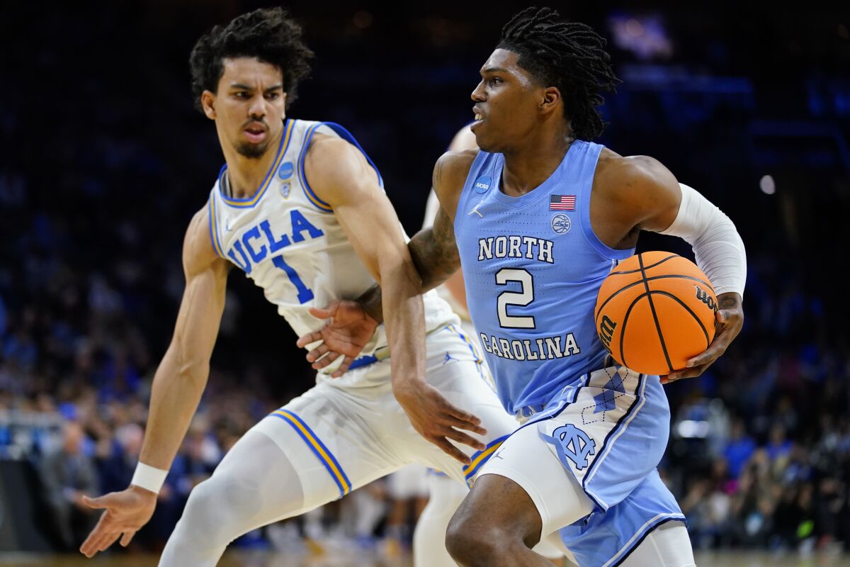 North Carolina's Caleb Love, right, tries to get past UCLA's Jules Bernard during the second half of a college basketball game in the Sweet 16 round of the NCAA tournament, Friday, March 25, 2022, in Philadelphia. (AP Photo/Matt Rourke)