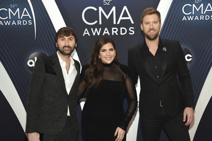 Dave Haywood, from left, Hillary Scott, and Charles Kelley of Lady Antebellum arrive at the 52nd CMA Awards.