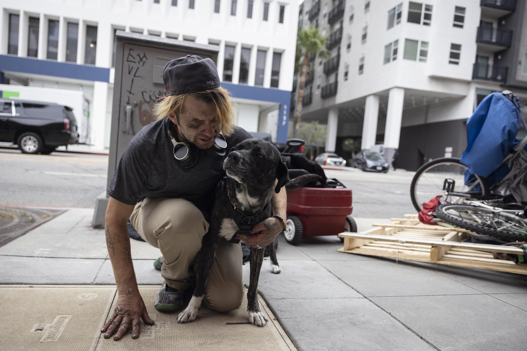 Una persona que experimenta la falta de vivienda sosteniendo a su perro