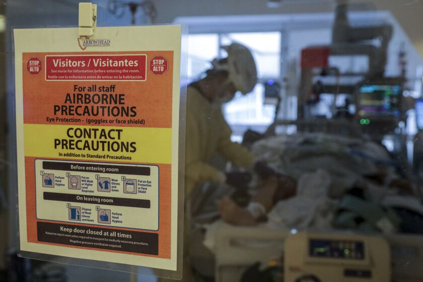 Colton, CA - December 22: A warning sign posted on the door of an intensive care unit where COVID patient is under treatment at Arrowhead Regional Medical Center on Wednesday, Dec. 22, 2021 in Colton, CA. (Irfan Khan / Los Angeles Times)