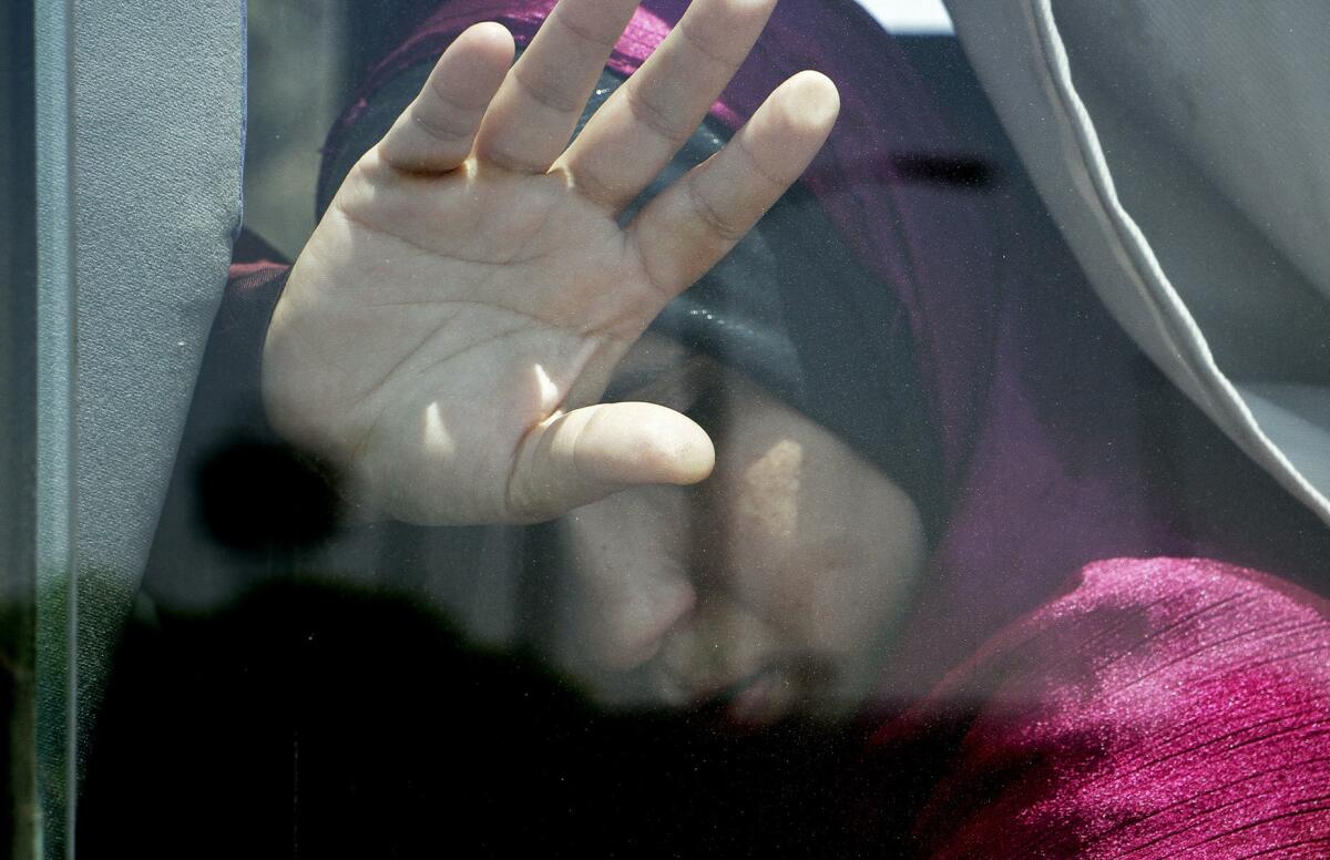A relative of a passenger on an EgyptAir flight that crashed early Thursday puts her hand on the window from inside a bus at Cairo International Airport, Egypt, on May 19, 2016.