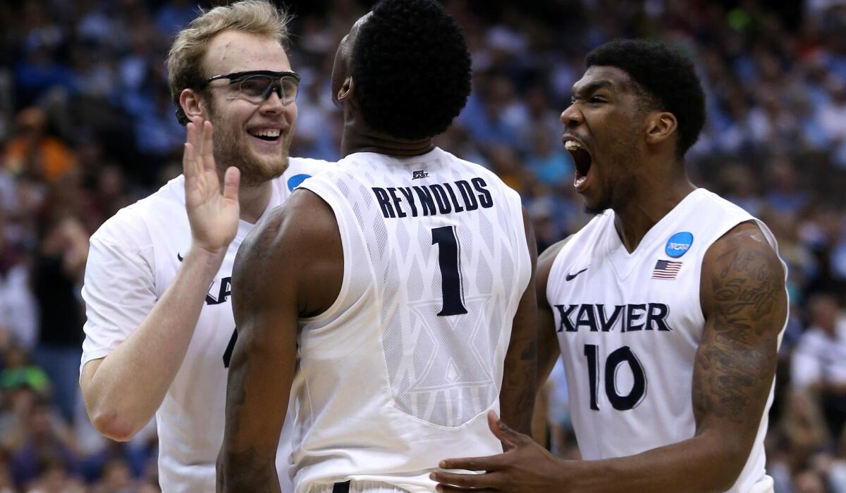 Xavier teammates (from left) Matt Stainbrook, Jalen Reynolds and Remy Abell celebrate during the second half of their victory over Georgia State on Saturday.