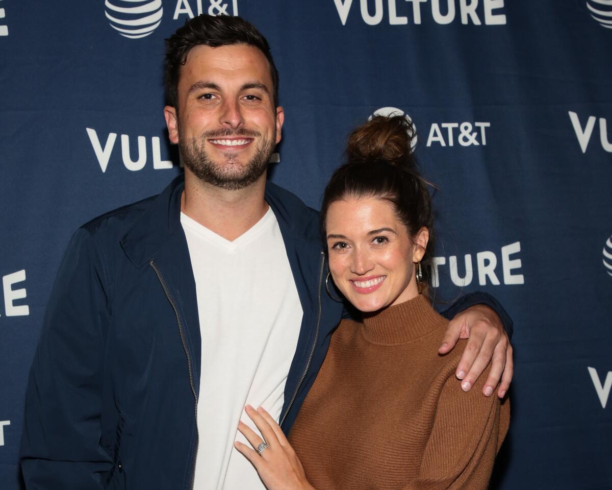 Tanner Tolbert poses with his arm around Jade Roper-Tolbert at a business-casual event