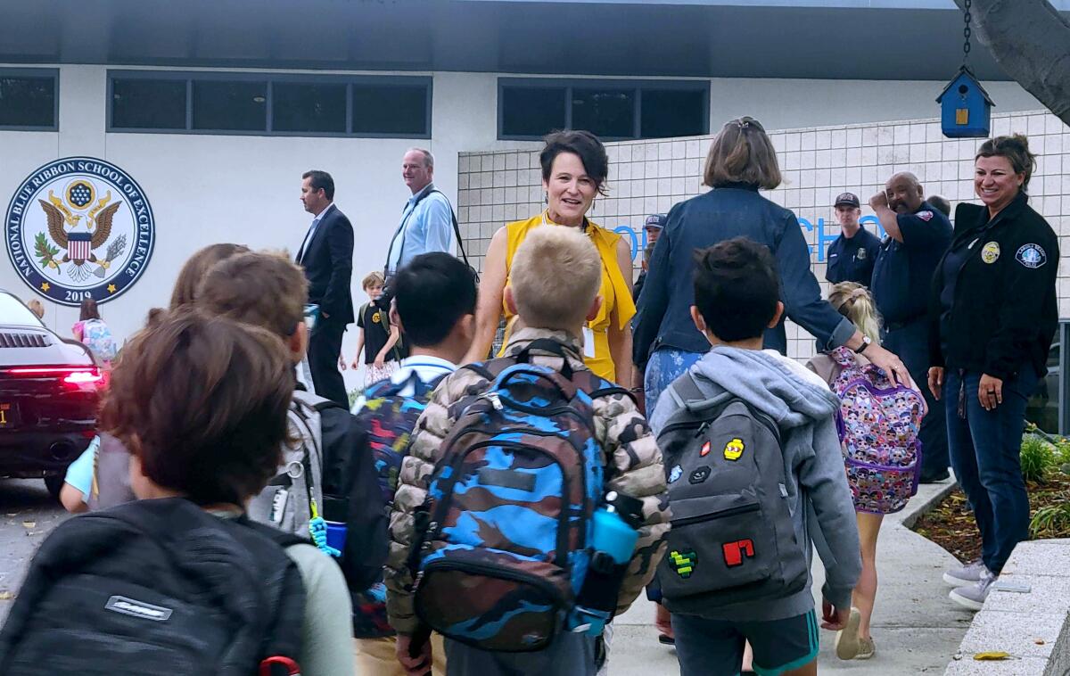 Laguna Beach school board president Carol Normandin, center, welcomes students back to school at El Morro Elementary.