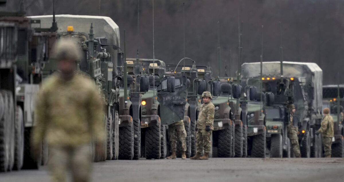 Soldiers of the 2nd Cavalry Regiment line up vehicles at the military airfield in Vilseck, Germany, Wednesday, Feb. 9, 2022 as they prepare for the regiment's movement to Romania loading of Stryker combat vehicles for their deployment to support NATO allies and demonstrate U.S. commitment to NATO Article V. The soldiers will deploy to Romania in the coming days from their post in Vilseck and will augment the more than 900 U.S. service members already in Romania. This Stryker Squadron represents a combined arms unit of lightly armored, medium-weight wheeled combat vehicles. (AP Photo/Michael Probst)