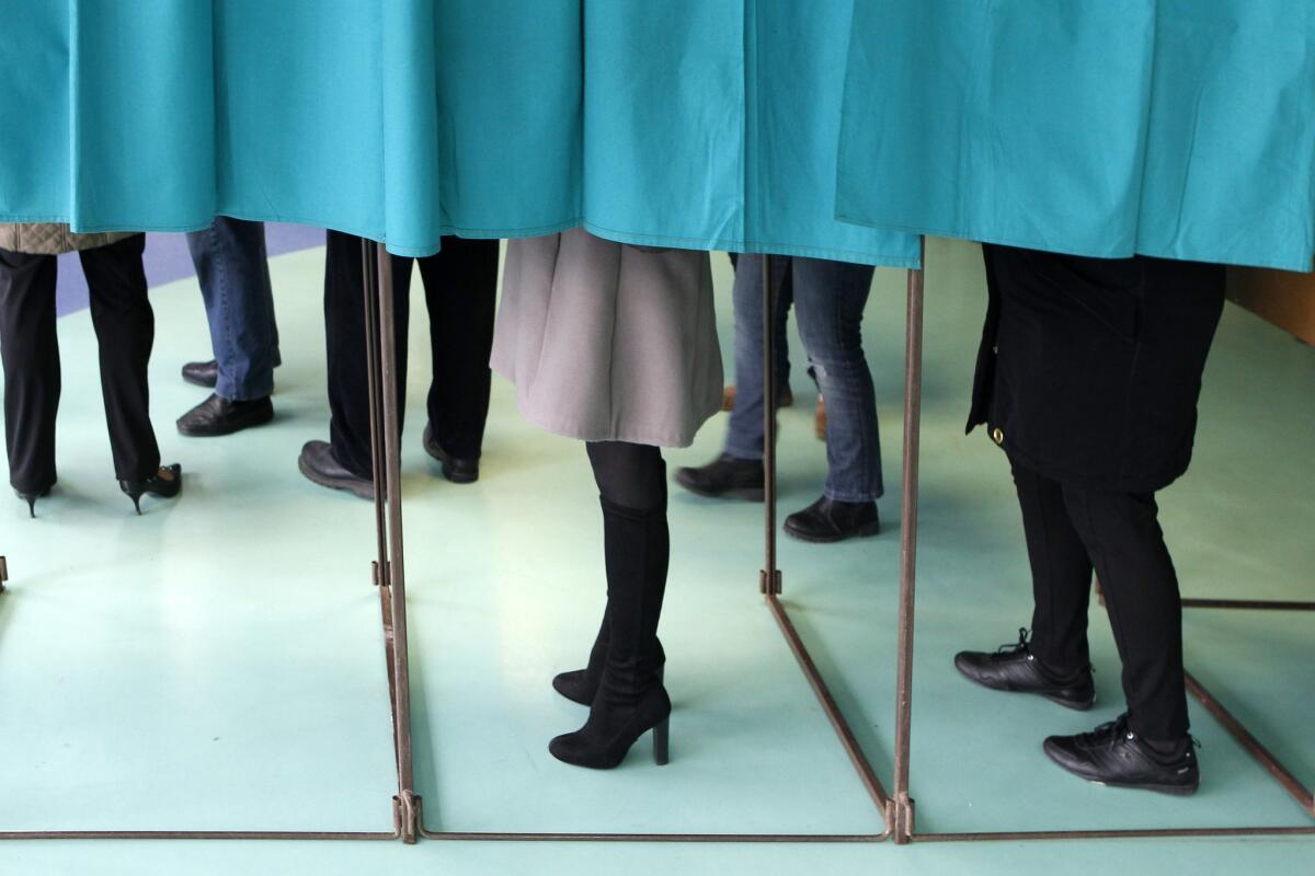 Voters fill out ballots in polling booths during the first round of the local elections in Henin-Beaumont, in northern France, on March 22.