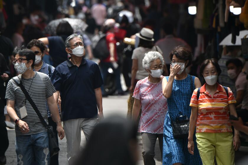 Pedestrians wearing face masks walk through a market in central Seoul on June 23, 2020. - South Korea reported 46 new coronavirus cases on June 23 after health authorities declared the country was battling a second wave of infections that had been circulating for weeks. (Photo by Jung Yeon-je / AFP) (Photo by JUNG YEON-JE/AFP via Getty Images)