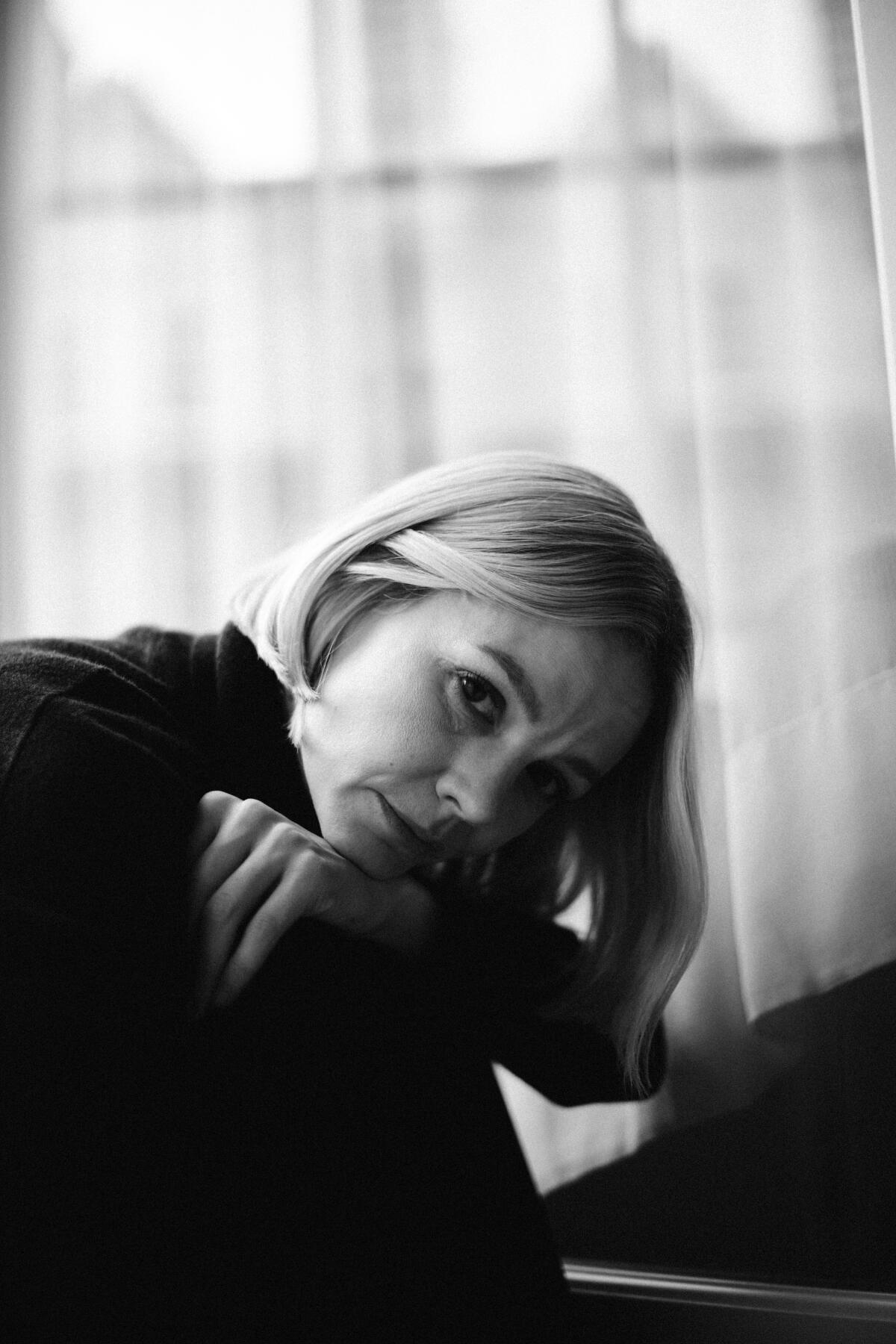 Carey Mulligan leunt met haar kin op haar armen in een zwart-witportret.