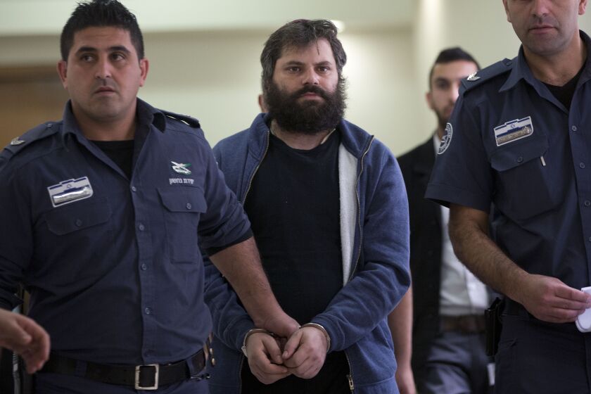 FILE - Israeli Yosef Haim Ben David, convicted in the killing of 16-year-old Palestinian Mohammed Abu Khdeir, arrives to a court in Jerusalem, Tuesday, April 19, 2016. An Israeli group that assists Jewish prisoners convicted in some of the country's most notorious hate crimes has halted its fund-raising efforts through a U.S.-based Jewish charity following an investigation by The Associated Press and the Israeli investigative platform Shomrim. (AP Photo/Oded Balilty, file)