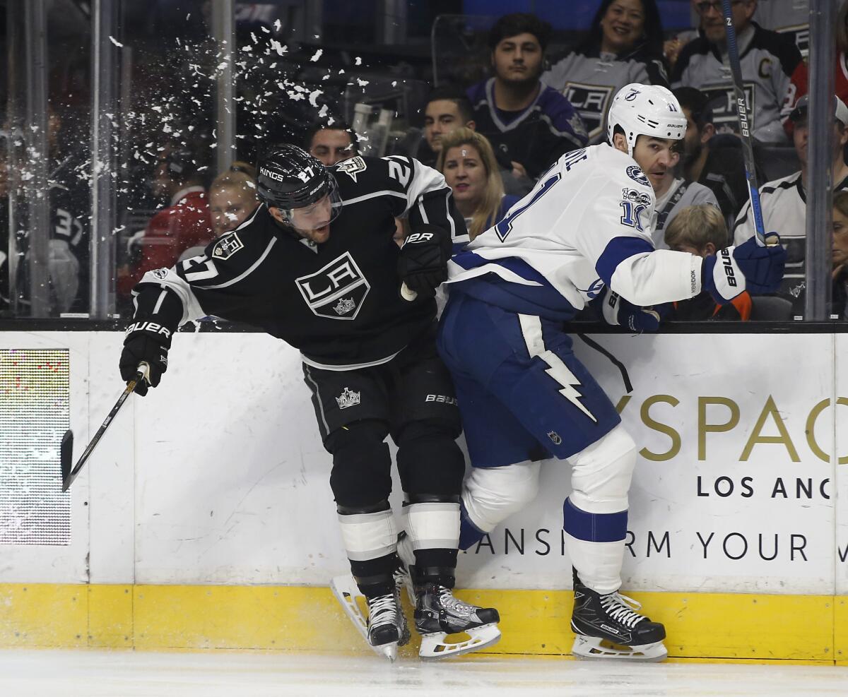 Kings defenseman Alec Martinez, left, checks Tampa Bay center Brian Boyle into the boards on Jan. 16.