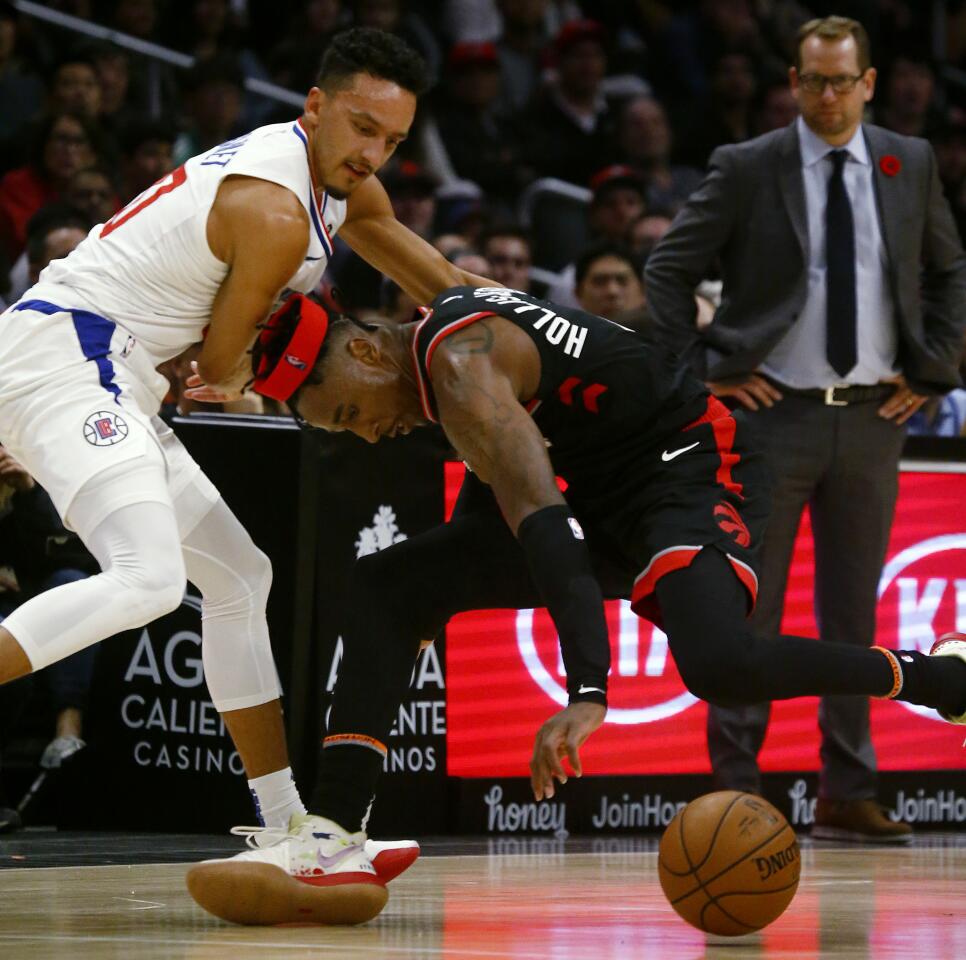 Clippers guard Landry Shamet gets tangled up with Raptors forward Rondae Hollis-Jefferson during a game Nov. 11 at Staples Center.