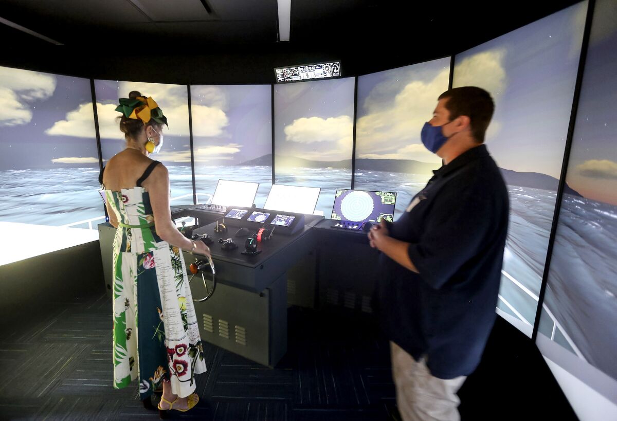 Mary Lynn Bergman-Rallis, left, takes the steering wheel of the new full bridge simulator.
