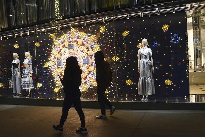People walk past a window display
