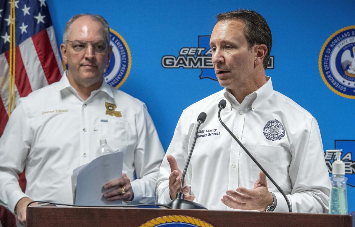 Louisiana Atty. Gen. Jeff Landry, right, speaks at a lectern with Gov. John Bel Edwards at his side