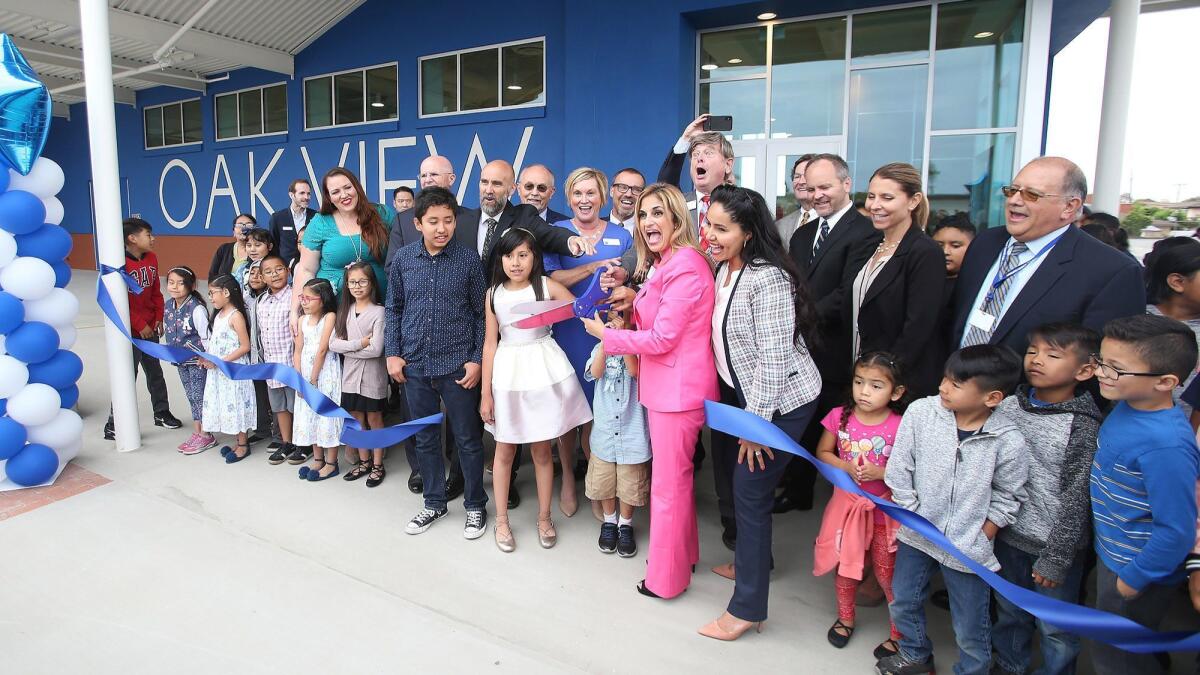Ocean View School District trustees Gina Clayton-Tarvin, in pink, and Patricia Singer, to her left, officially open Oak View Elementary School's new gym and multipurpose room on Monday.