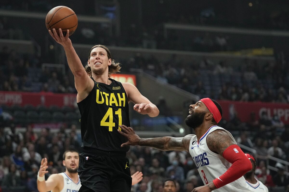 Utah's Kelly Olynyk puts up a shot in front of Clippers forward Marcus Morris Sr. during the Clippers' loss Sunday.