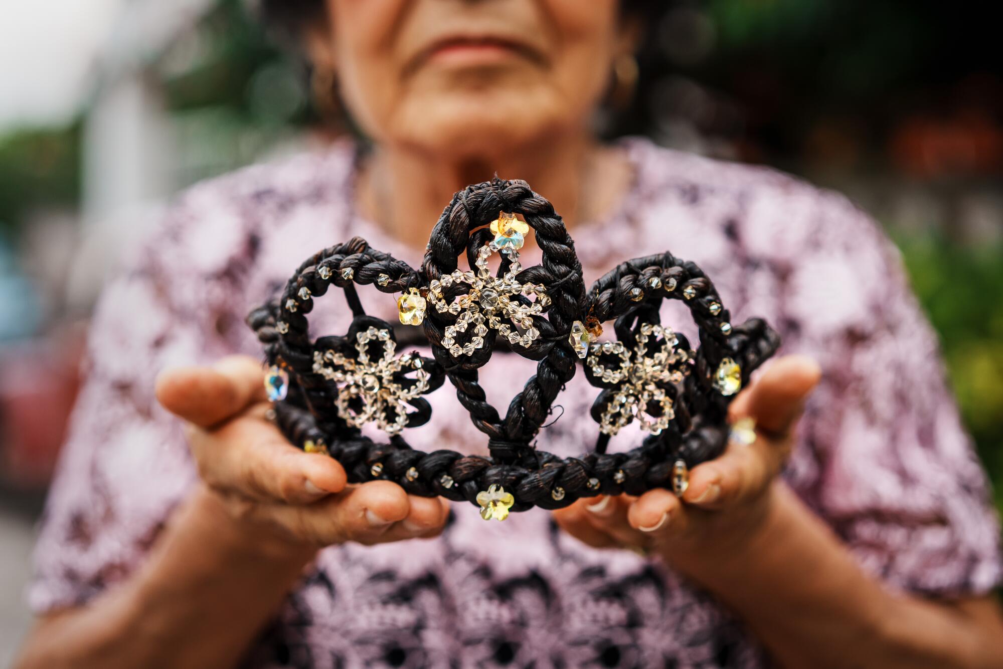 Alma Rosa González Herrera, 84, holds her vanilla crown in her hands.