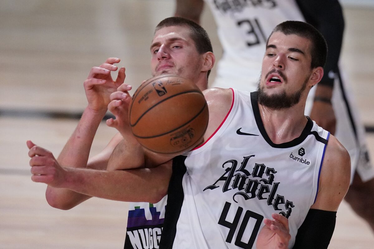 Denver Nuggets center Nikola Jokic and Clippers center Ivica Zubac battle for a rebound.